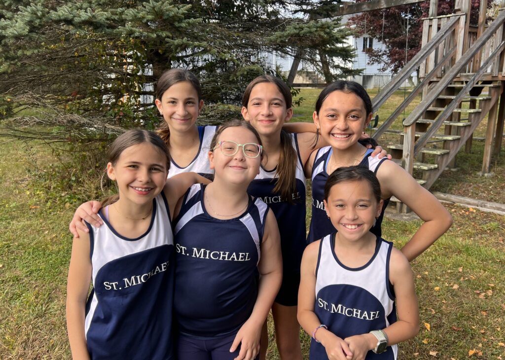 Group of six smiling young girls in blue and white school track uniforms